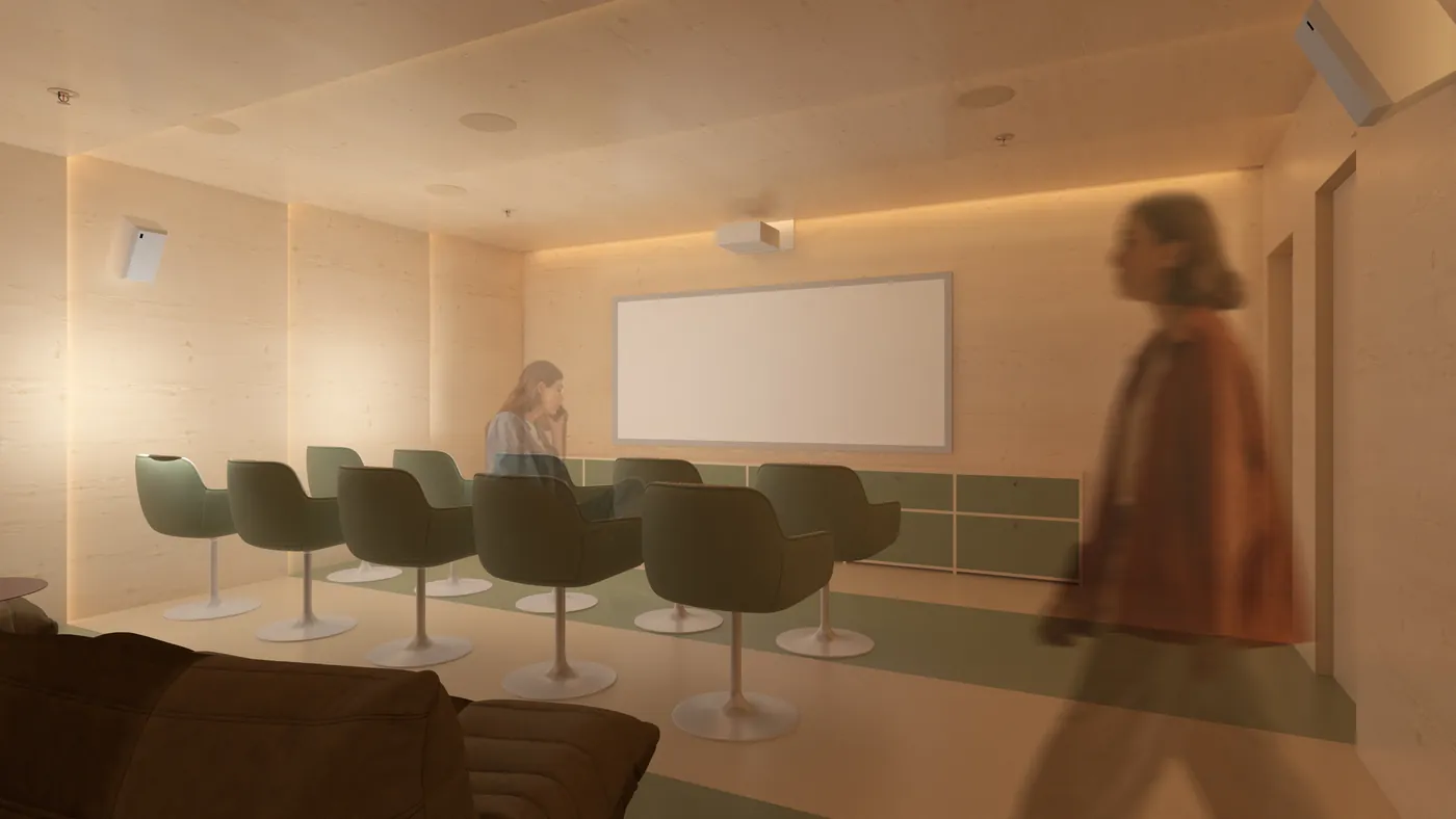 The media room at The Herring, with tiered green armchairs facing a large screen.